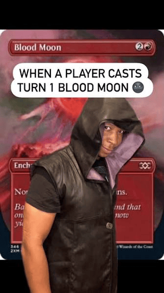 A person wearing a hooded vest stands in front of a card labeled 'Blood Moon' from a trading card game. The card's text is partially visible, along with an expressive facial expression conveying surprise or seriousness.